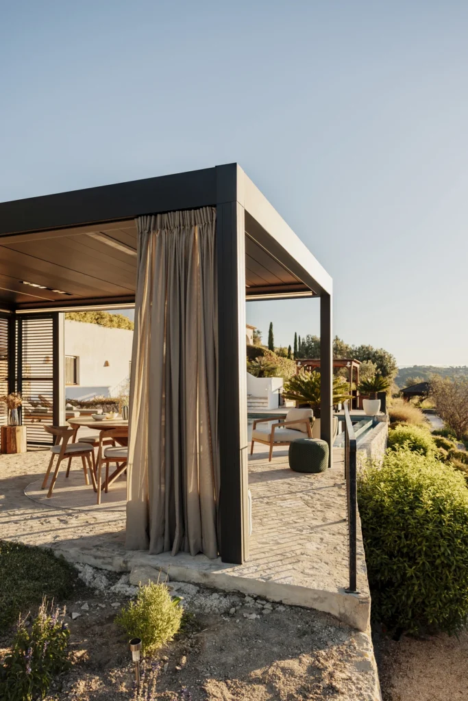 La pérgola Camargue de Renson con cortinas de exterior combina diseño moderno, confort y protección frente al sol y la lluvia. Sus lamas orientables y accesorios integrables permiten disfrutar del aire libre todo el año.