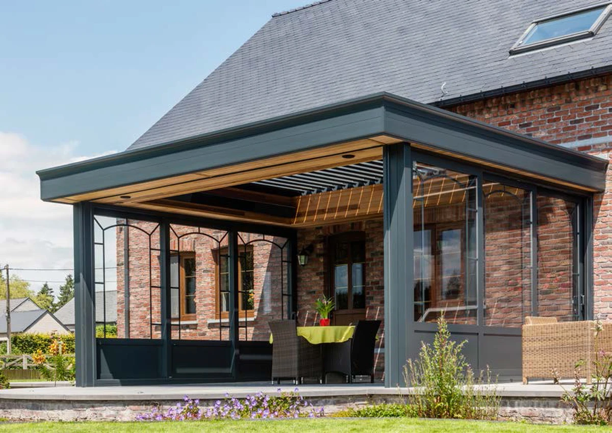 Pérgola bioclimática Aero Renson integrada en pergola que ya existe, lamas orientables para control de luz solar.