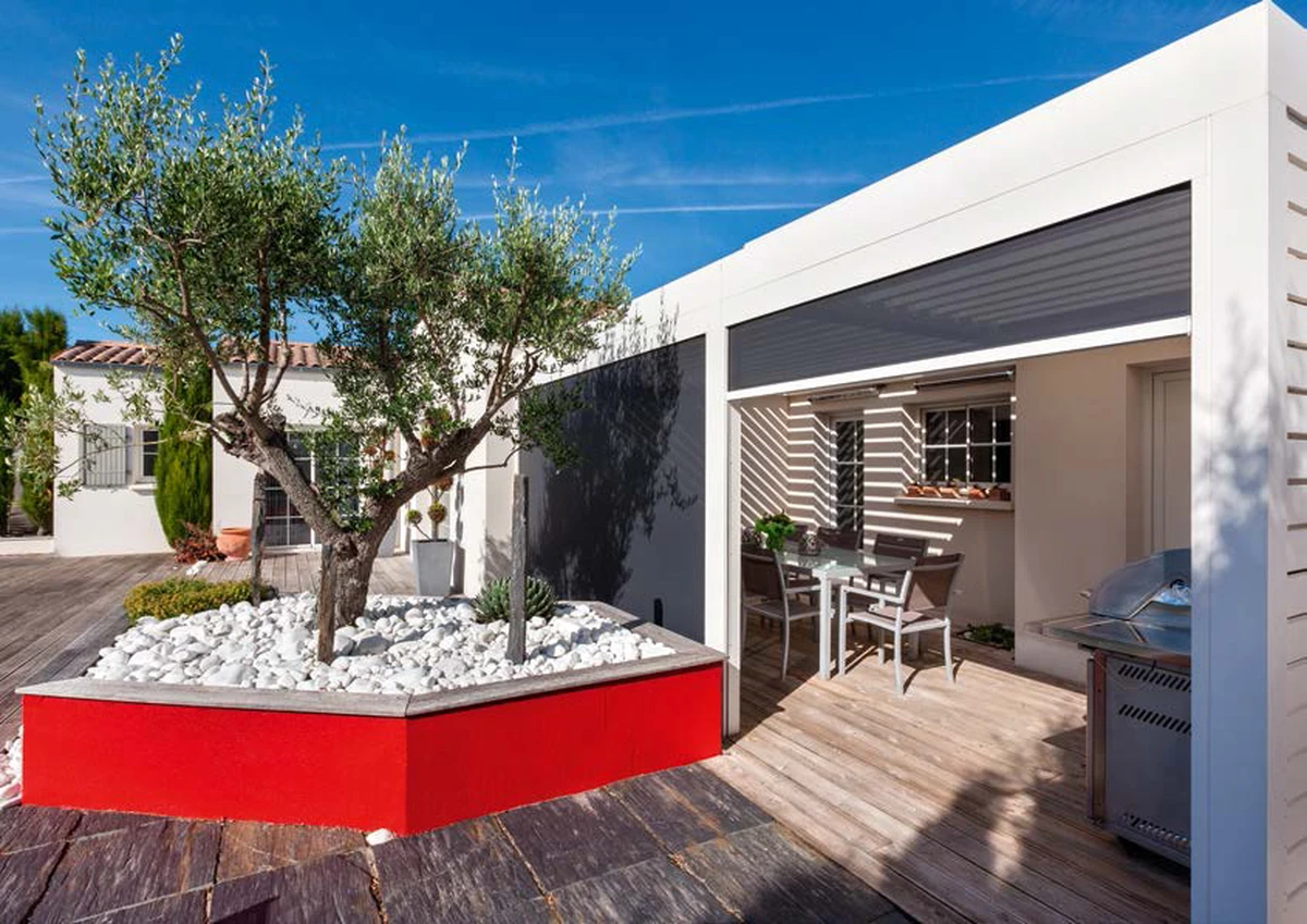 Pérgola Algarve adosada a casa, con lamas orientables, zip-screens laterales y panel de aluminio lateral