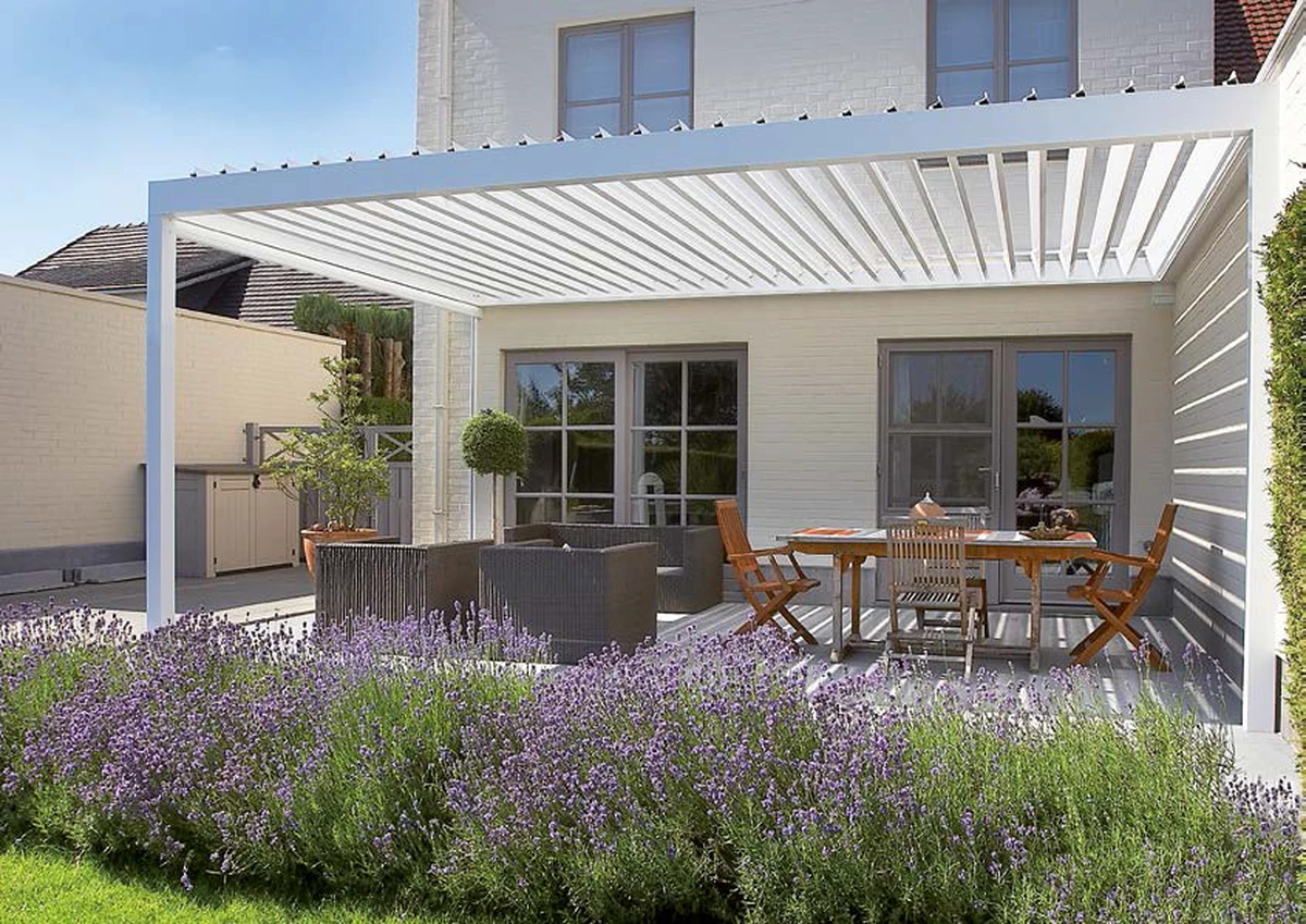 Pérgola Algarve blanca adosada a casa con lamas orientables.