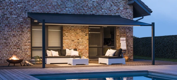 La pérgola COFRE Lapur de Renson por la noche, con luz LED integrada, ofrece un espacio exterior acogedor, personalizado y elegante, perfecto para disfrutar del aire libre con confort y estilo.